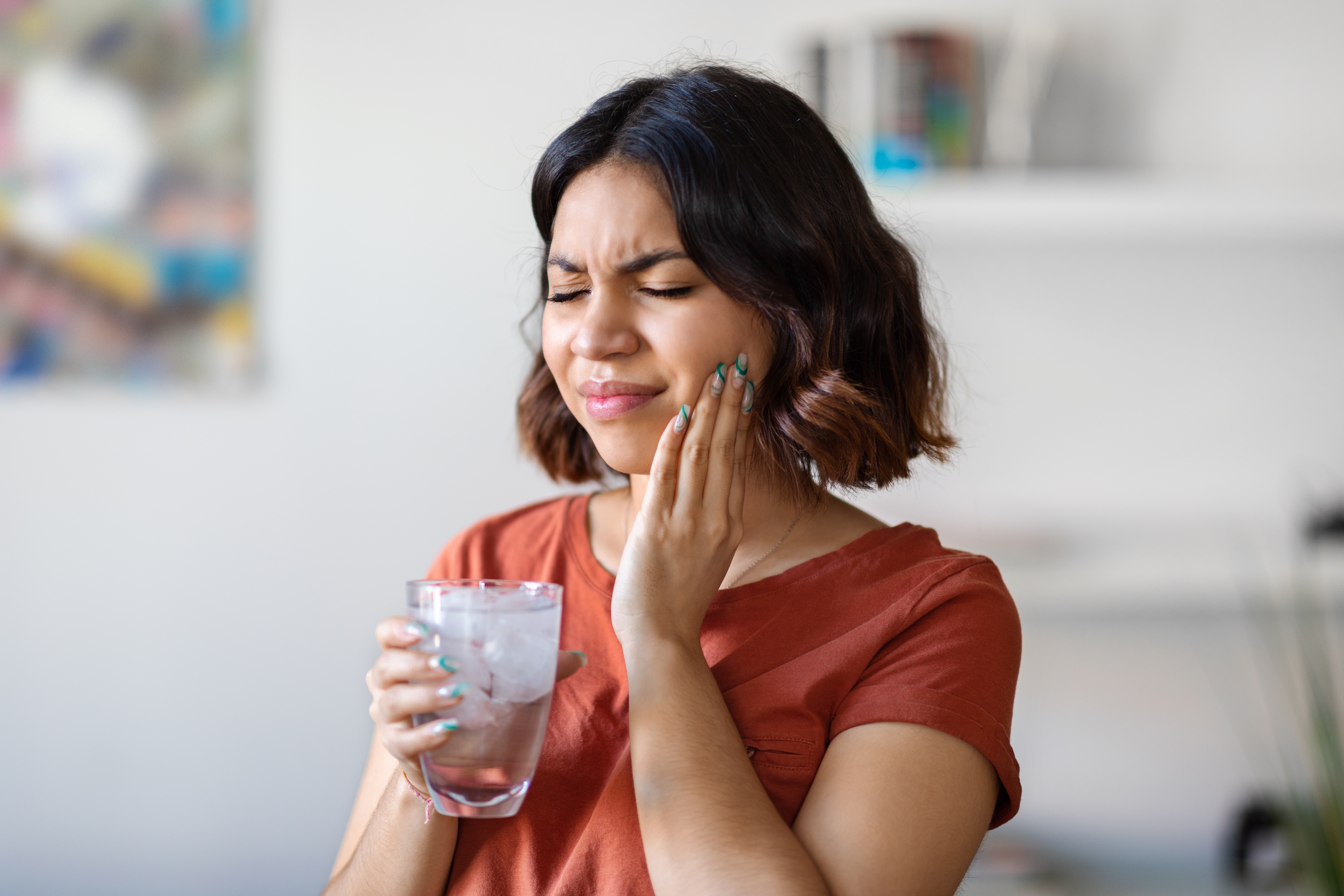 A person touching their face where they have sensitive teeth | Crest 