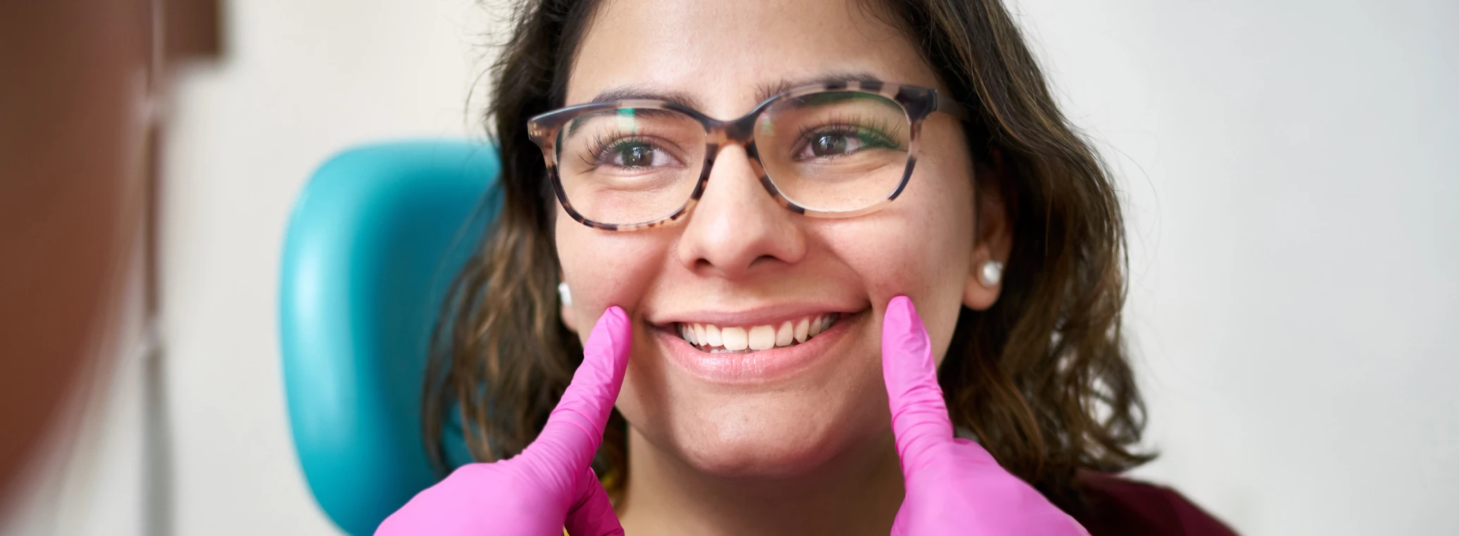 Dentist examining a patient's mouth whilst patient smiles