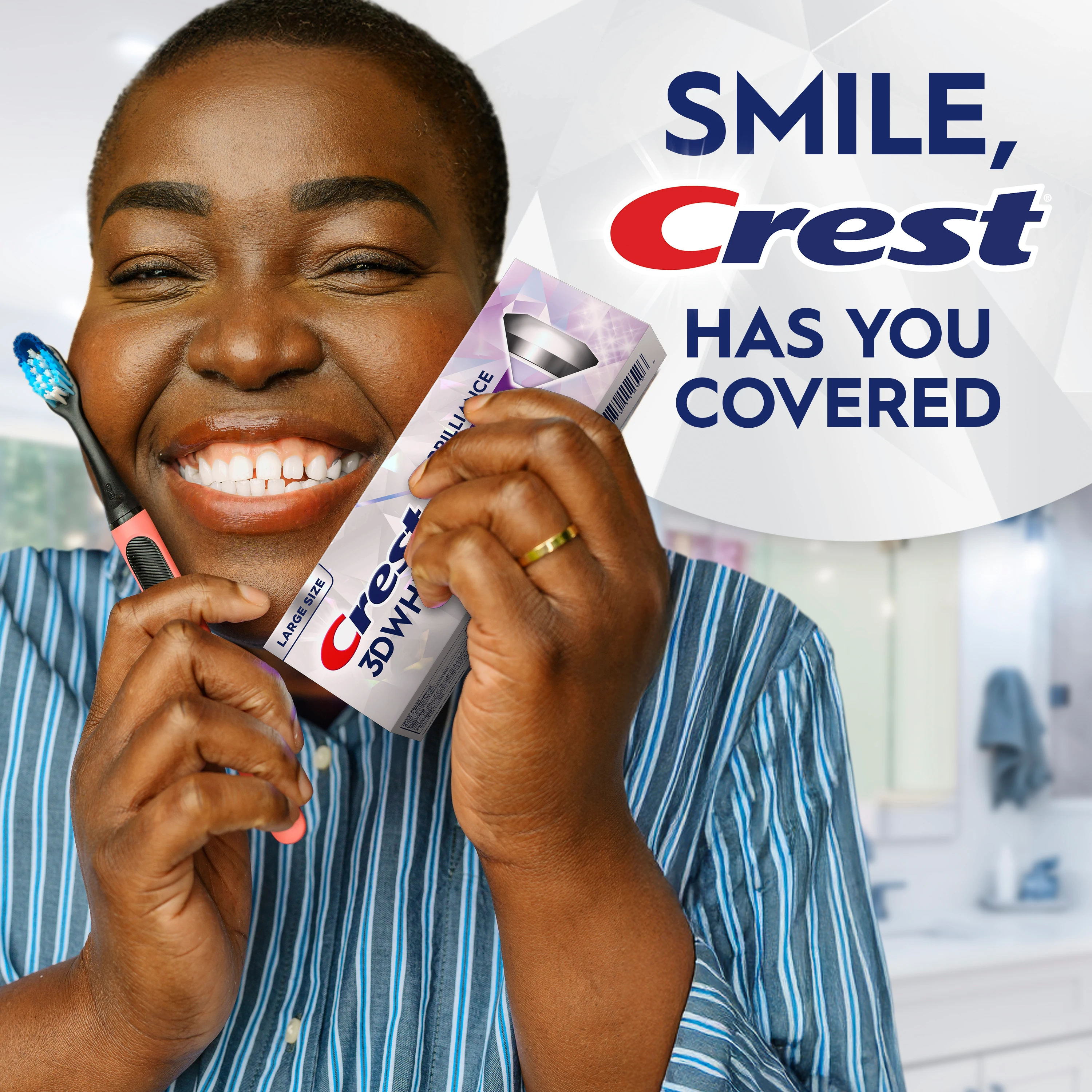 Woman smiling and holding a toothbrush with the Crest 3DWhite Brilliance Vibrant Peppermint Teeth Whitening Toothpaste.