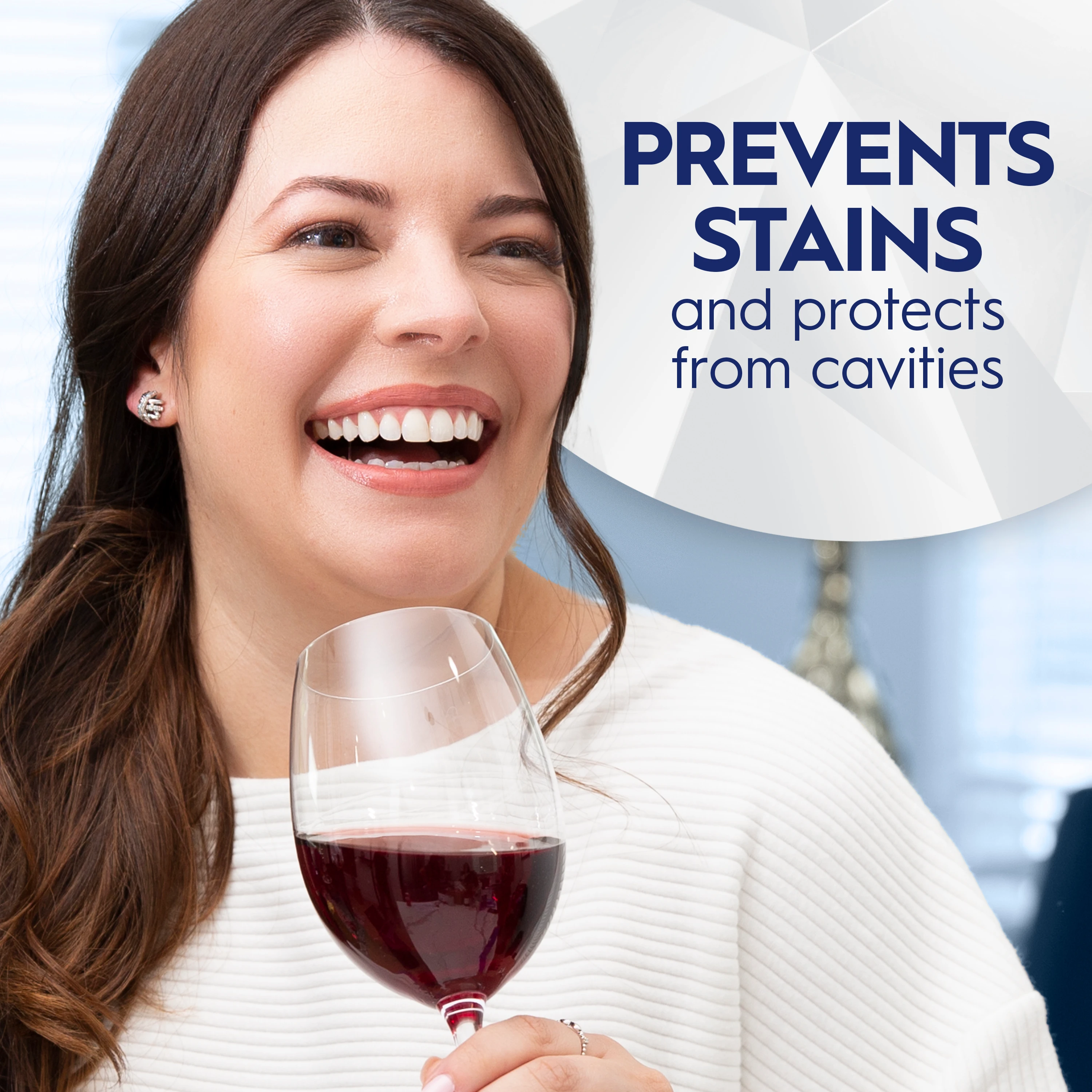 Woman smiling and holding a glass of wine. Prevents stains and protects from cavities.