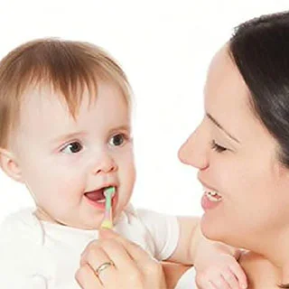 Woman brushing baby's teeth