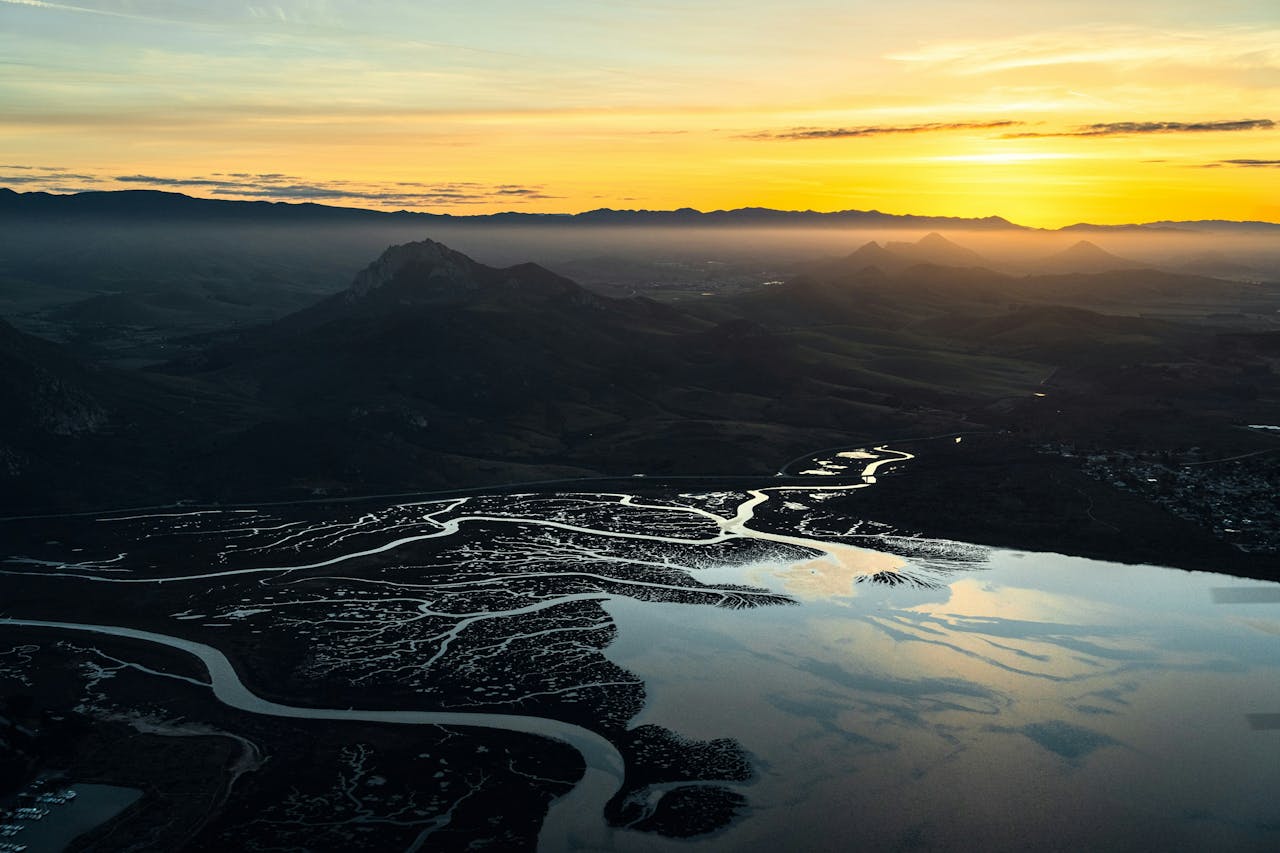 Sunset over a river and mountains, photo by Jeremy Bishop on Pexels