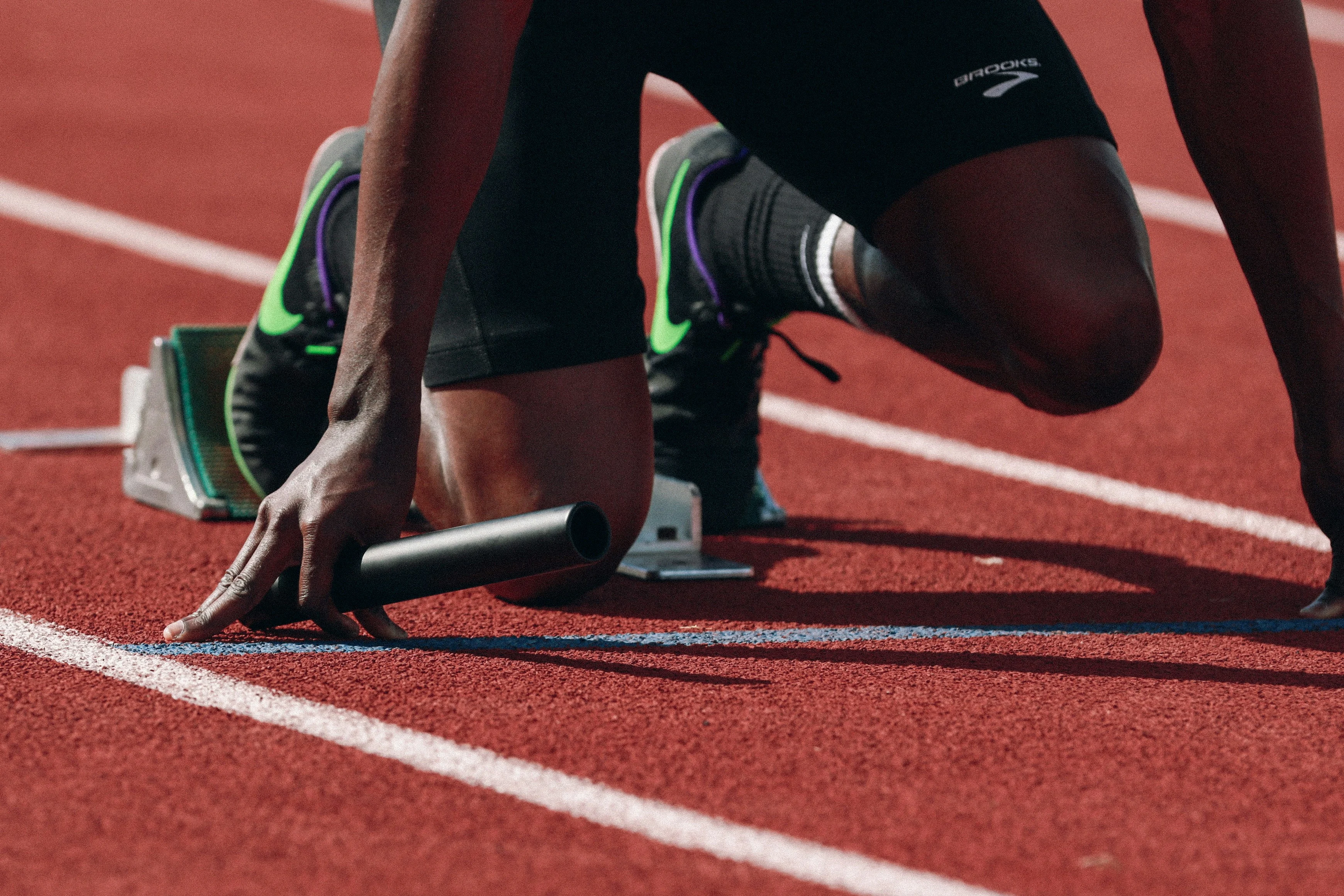 Runner kneeling on starting blocks