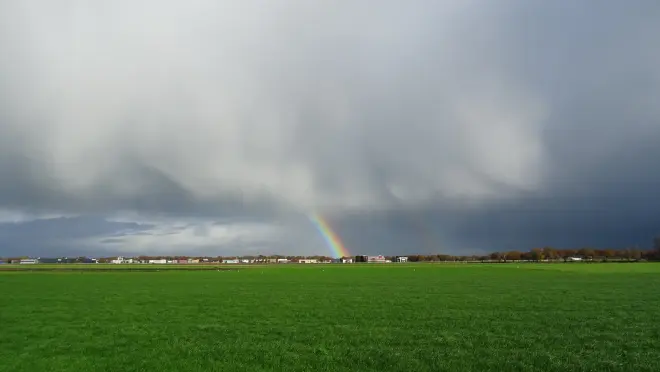 Een bui, met hagelscherm en regenboog, boven het Friese land - Albert Thibaudier