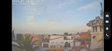 De zon van boven, links van het midden (onder de palm) de zonnepanelen op het dak van de garage - webcambeeld