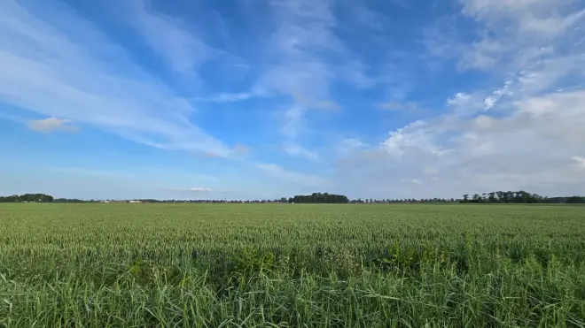 De zon schijnt boven de akkers rond Roodeschool - Jannes Wiersema. 