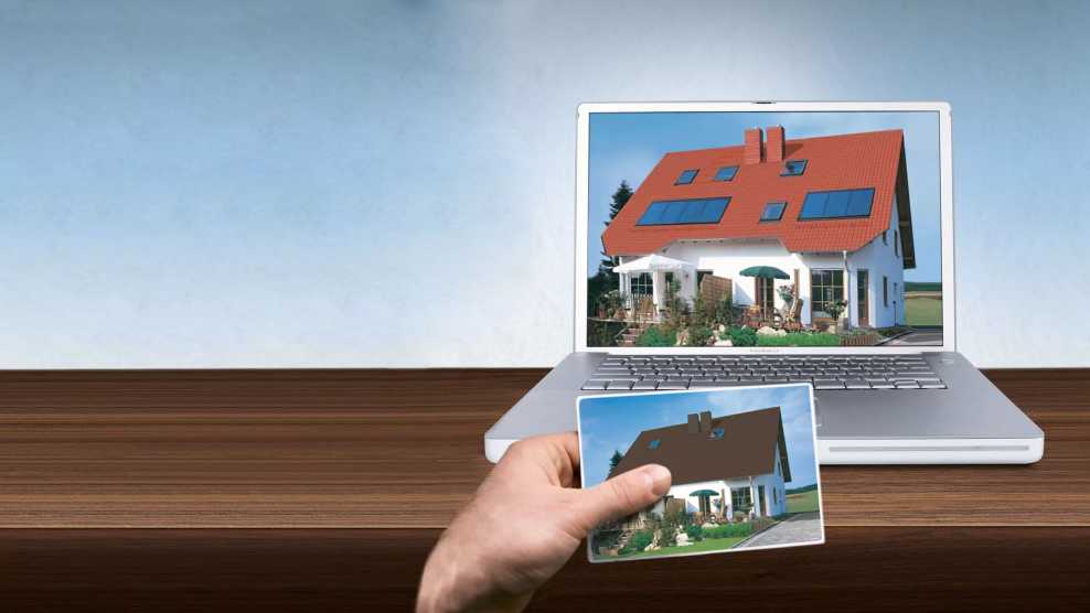 Laptop zeigt ein Haus mit neuer Dacheindeckung und man sieht ein Foto des Hauses vor der digitalen Bearbeitung mit der ursprünglichen Eindeckung