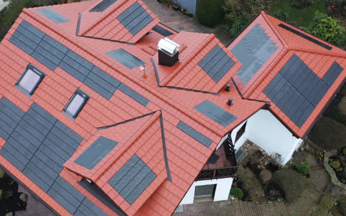Haus mit komplizierten Dachflächen und integrierten Solaranlagen.