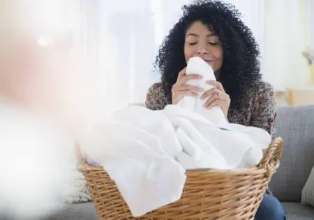 Mulher a cheirar toalhas limpas