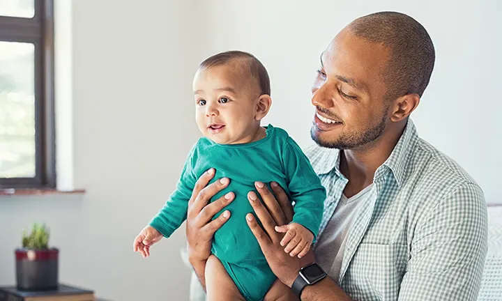 Un père travaillant à la maison avec son bébé