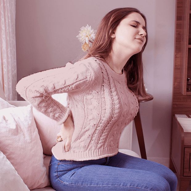 Mujer en casa con dolor de espalda