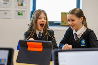 Two girls looking at a tablet