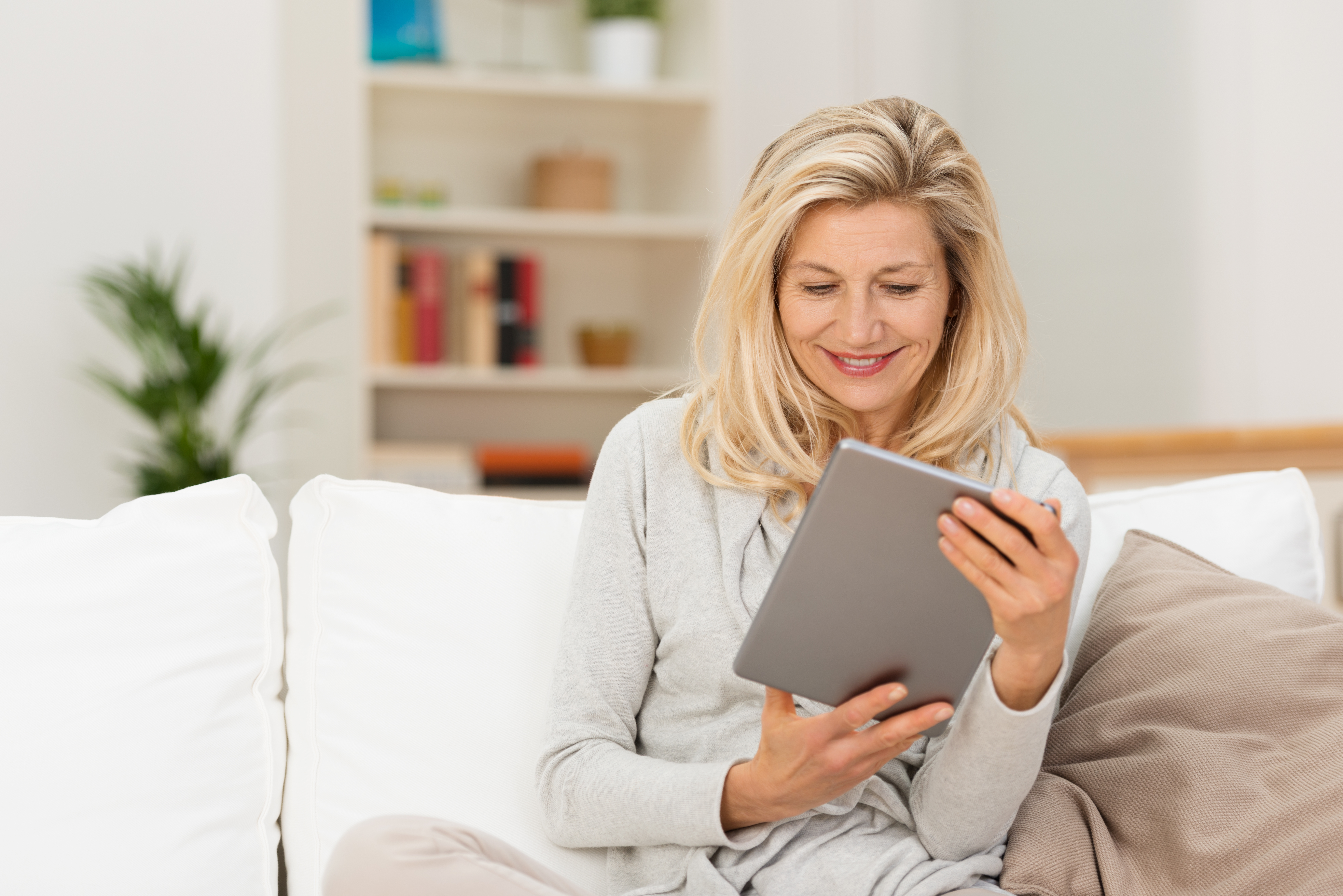 Woman with an ipad considering her hair