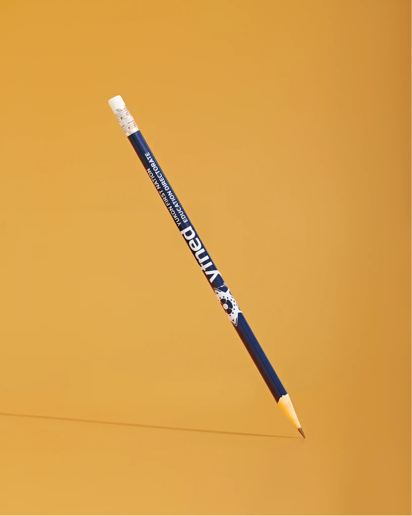 Blue YFNED wooden pencil with white eraser, floating diagonally on a gold background.