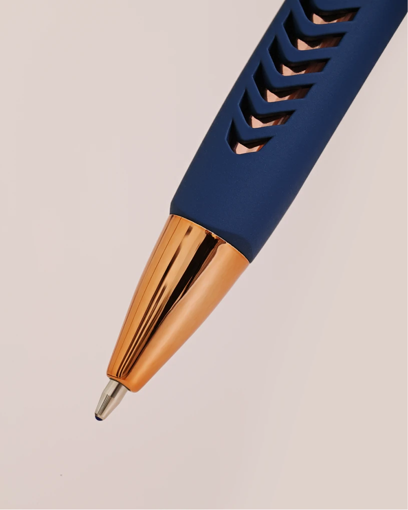 Close-up of blue YFNED pen tip with gold metal point and textured grip.