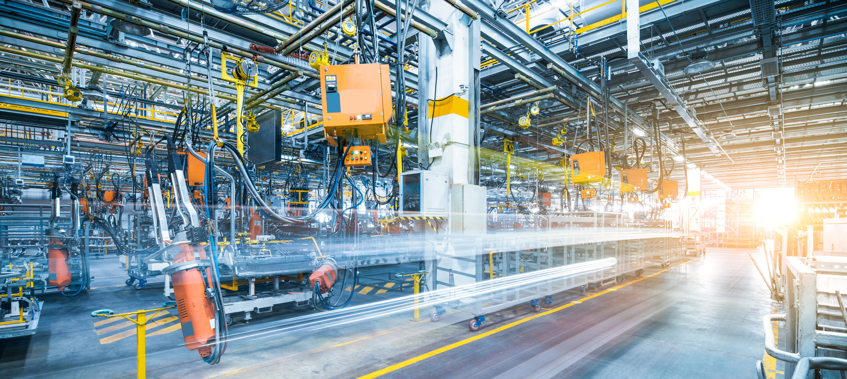 Automated manufacturing facility with industrial machinery, robotic equipment and production lines operating on a factory floor.