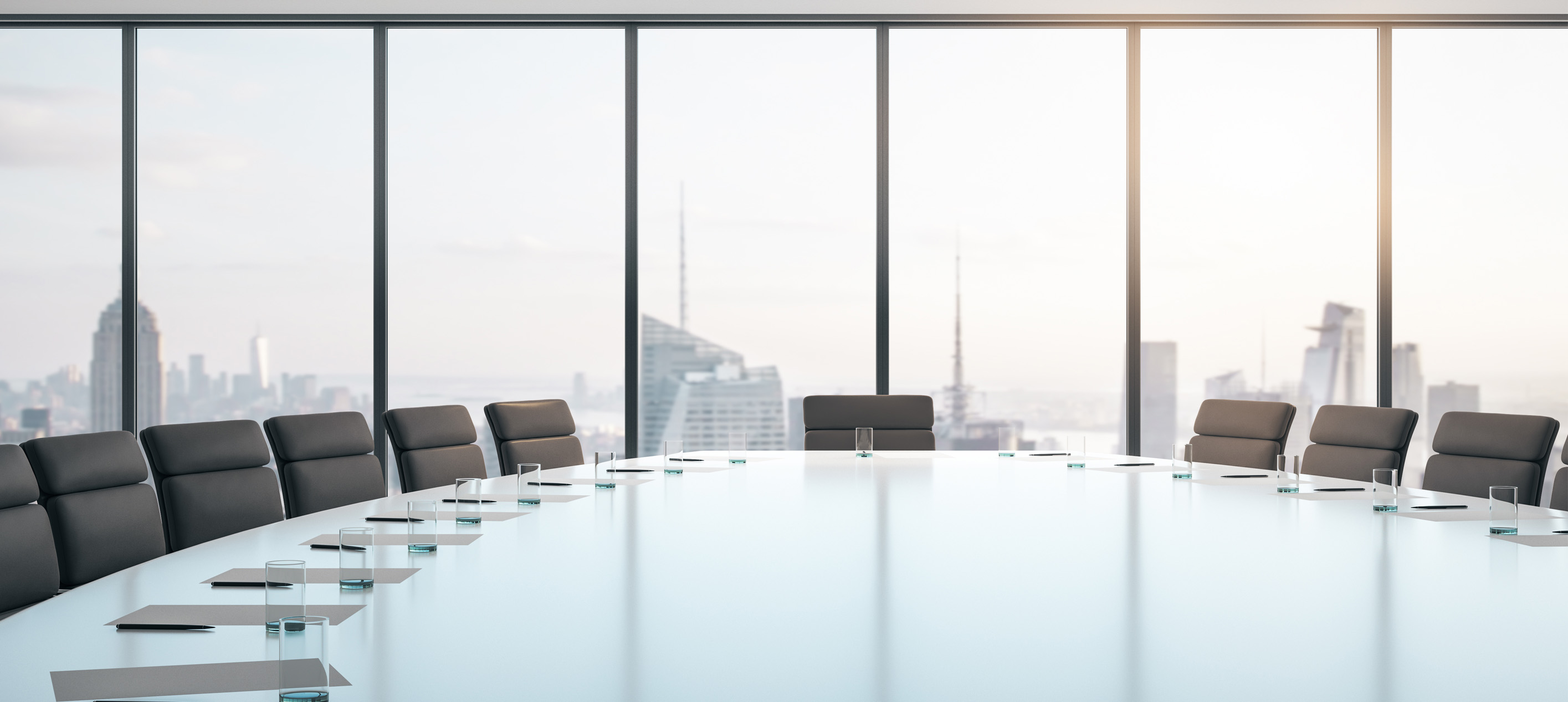 Modern boardroom with conference table and city skyline