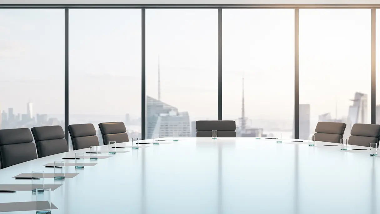 Modern boardroom with conference table and city skyline