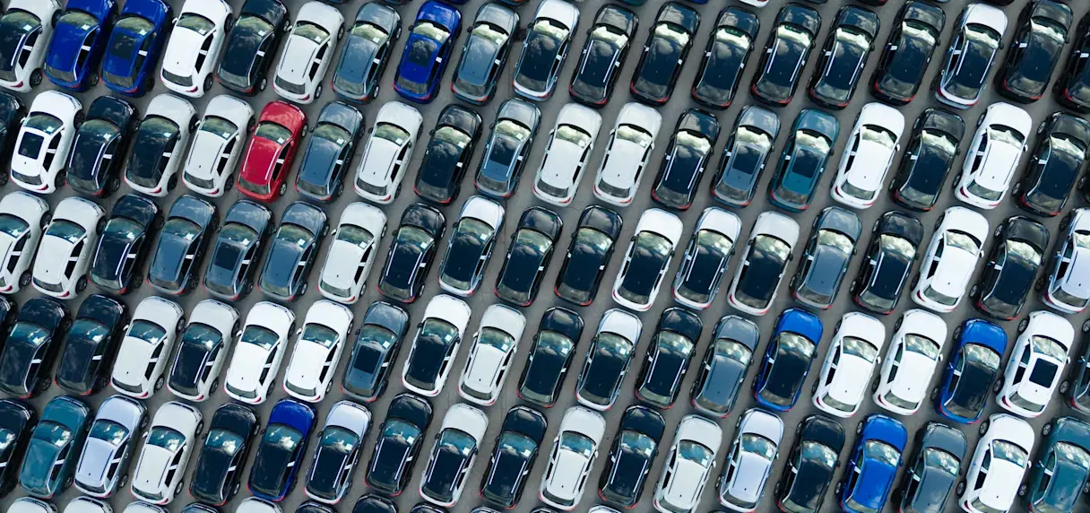 Aerial view of rows of parked new cars in various colors.