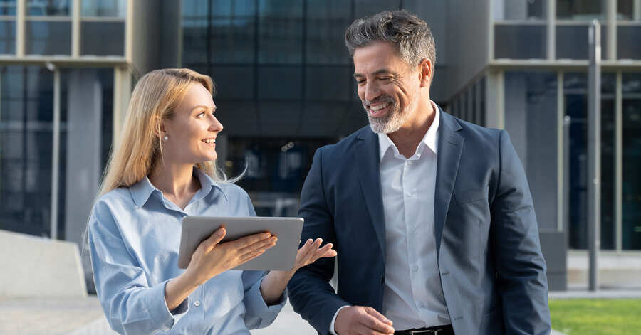 Two professionals walking outside of a building