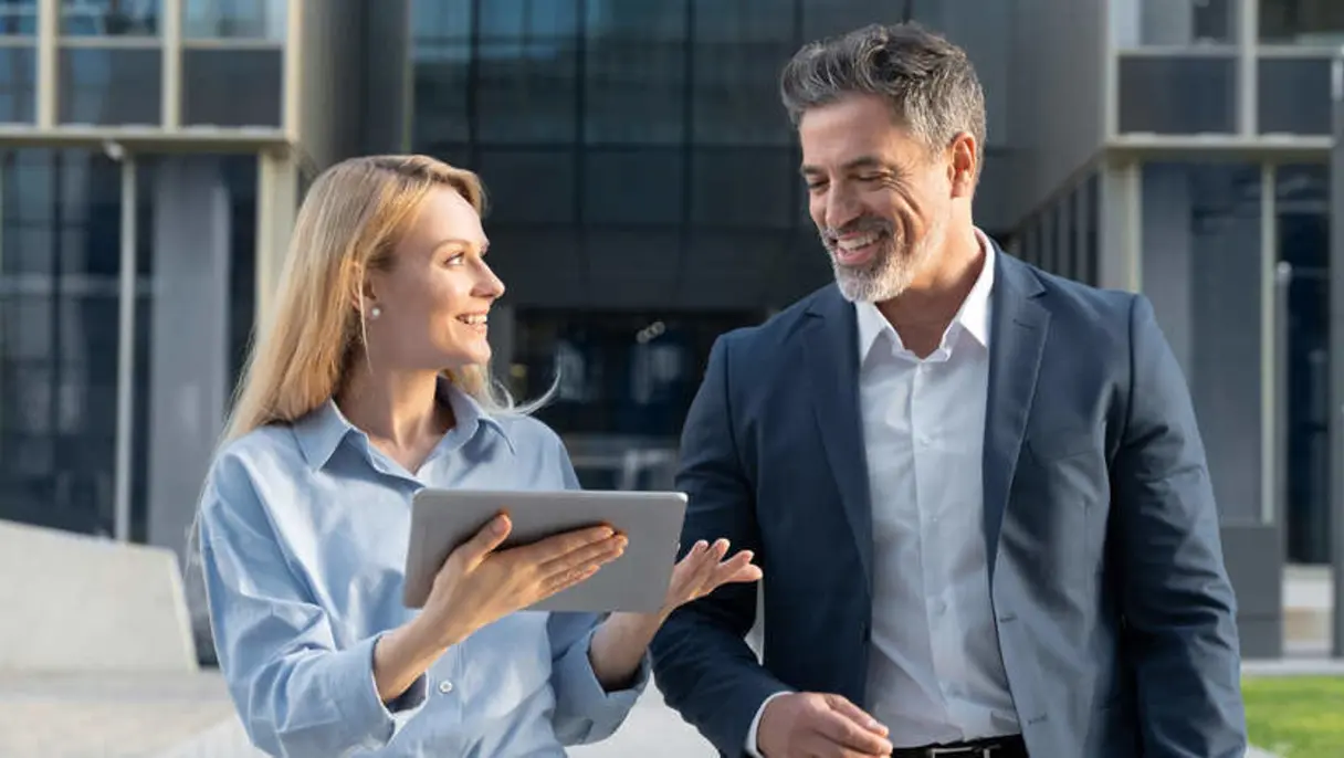 Two professionals walking outside of a building