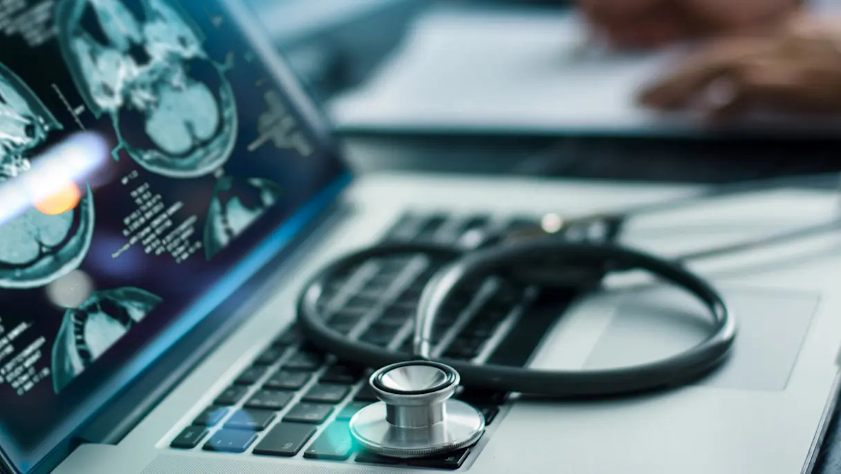 Stethoscope on laptop with brain scans on the screen