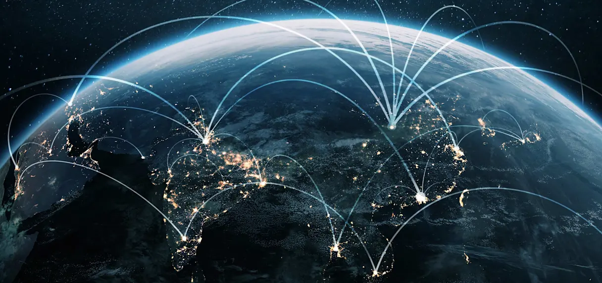 Satellite view of Earth at night over Asia-Pacific with illuminated cities and curved connection lines across the region.