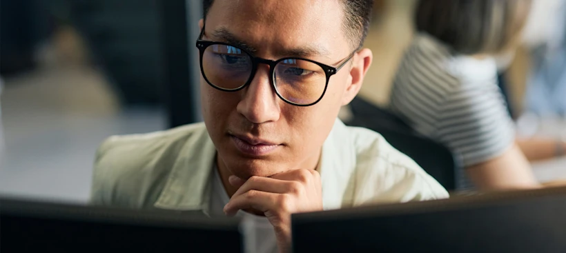 A person looking at two computer screens