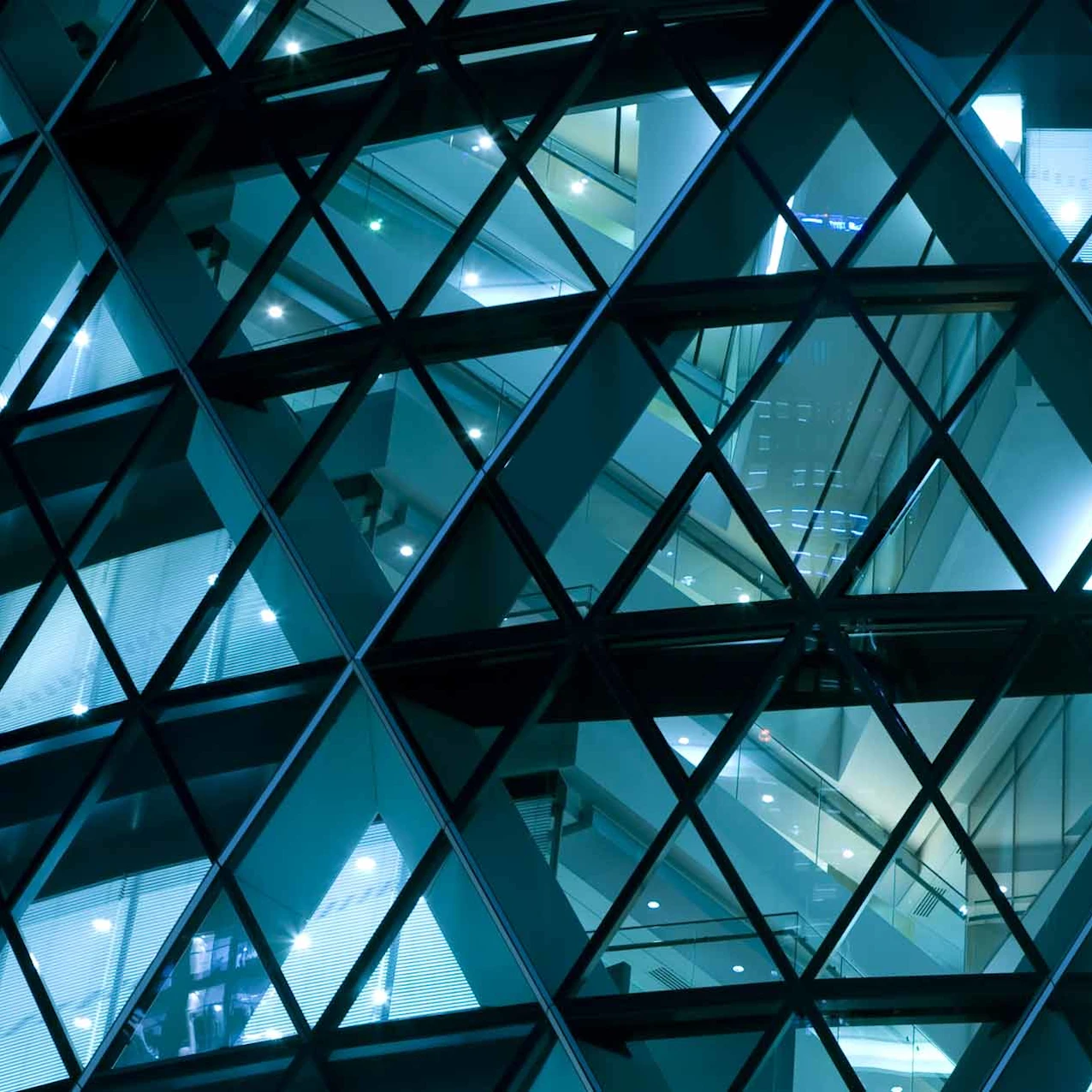 Geometric glass facade lit at night.