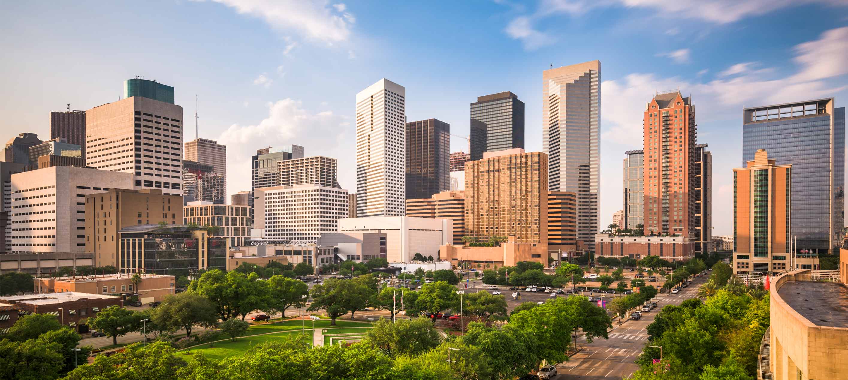 Downtown Houston skyline with modern office towers, green parkland and major business district in Texas.