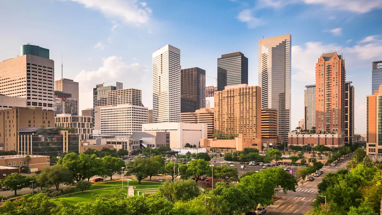 Downtown Houston skyline with modern office towers, green parkland and major business district in Texas.