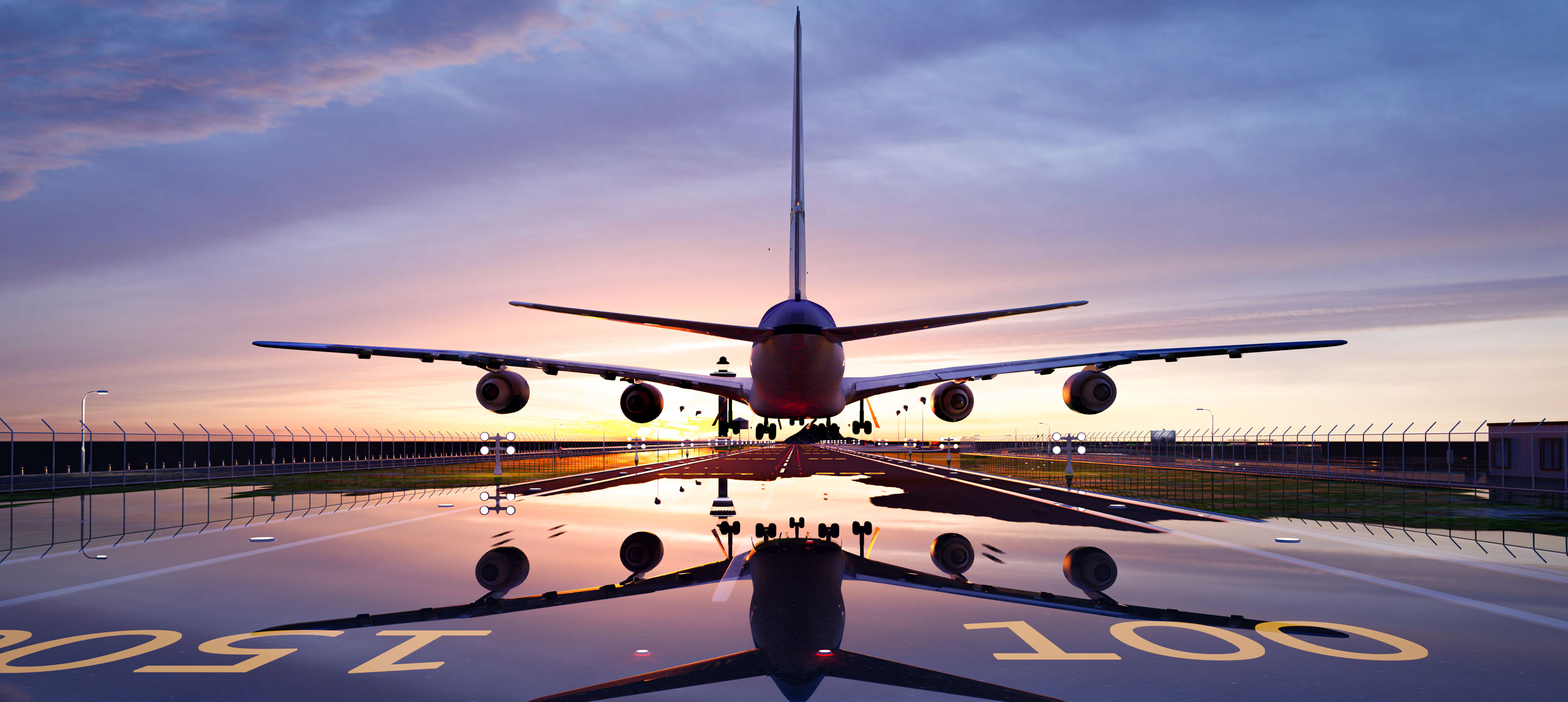 Front view of a commercial aircraft on a runway at sunset with landing lights and reflection on wet tarmac.