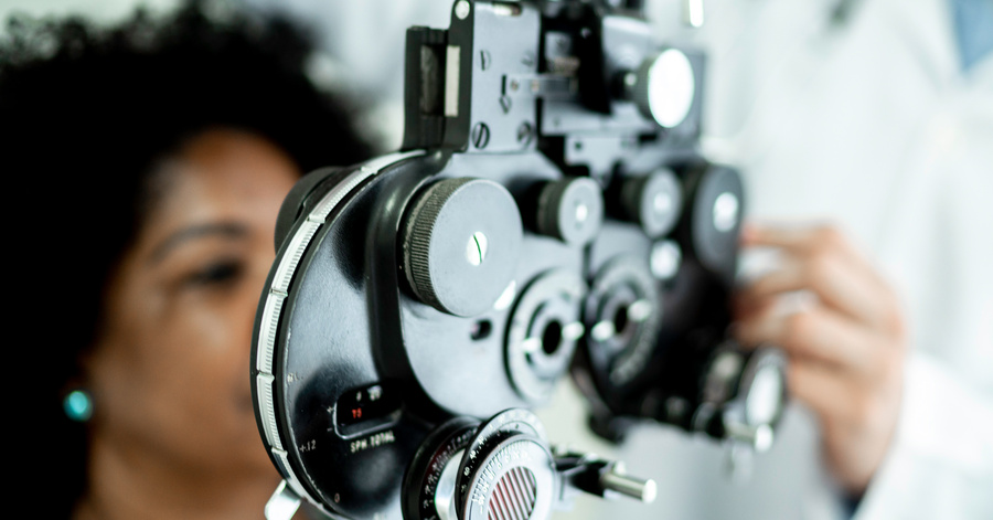 A Women Looking Through Eye Testing Machine