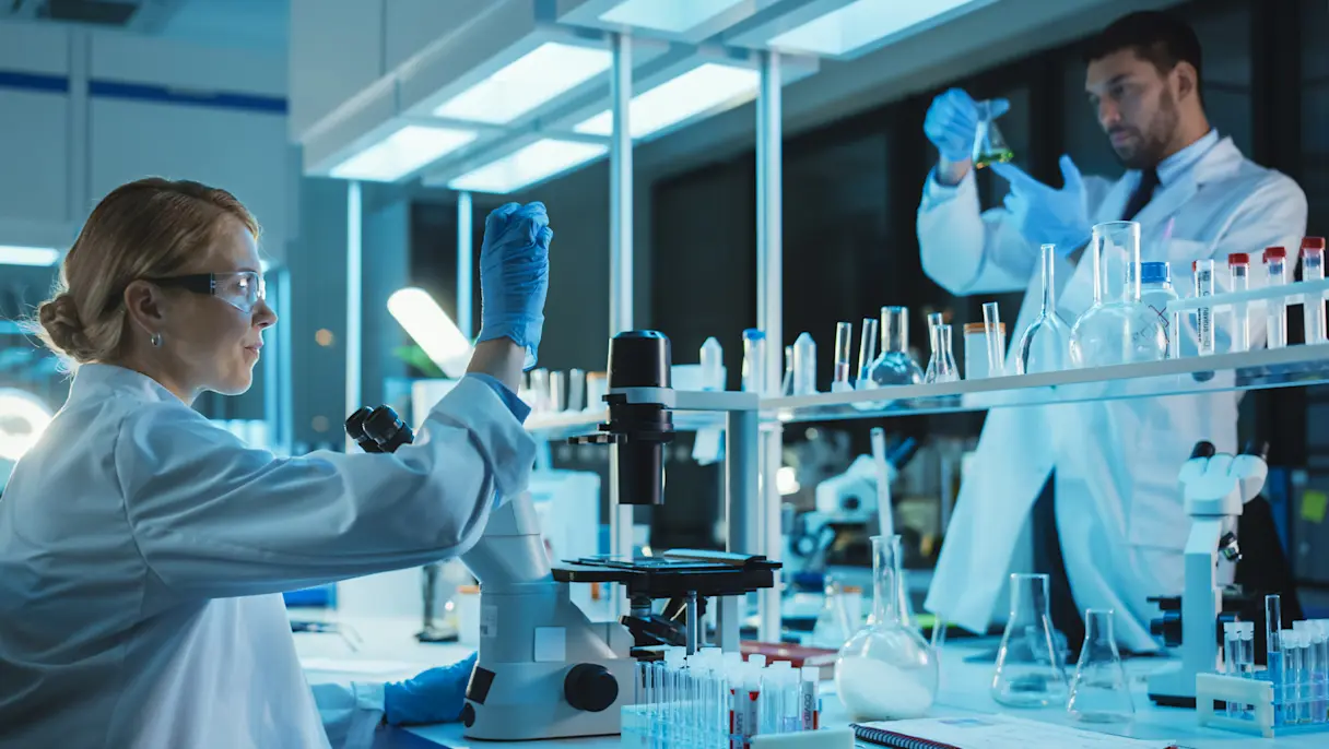 Two chemist in white lab coat conducting an experiment