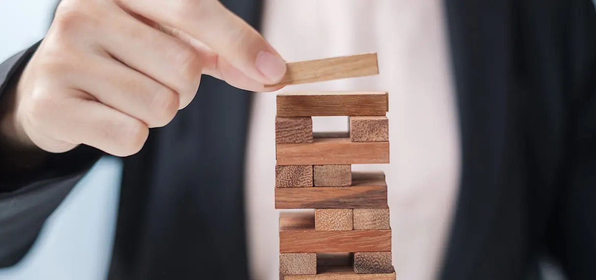 Businesswoman placing a wooden block on stack on wooden blocks