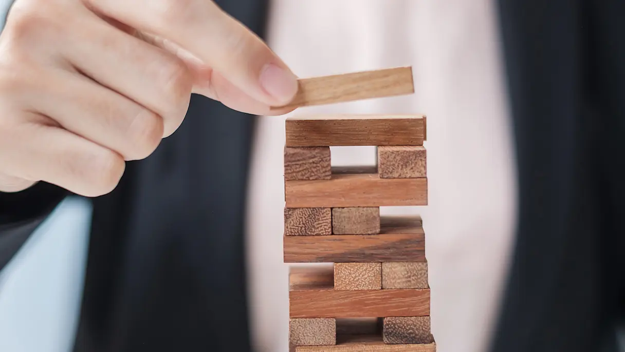 Businesswoman placing a wooden block on stack on wooden blocks
