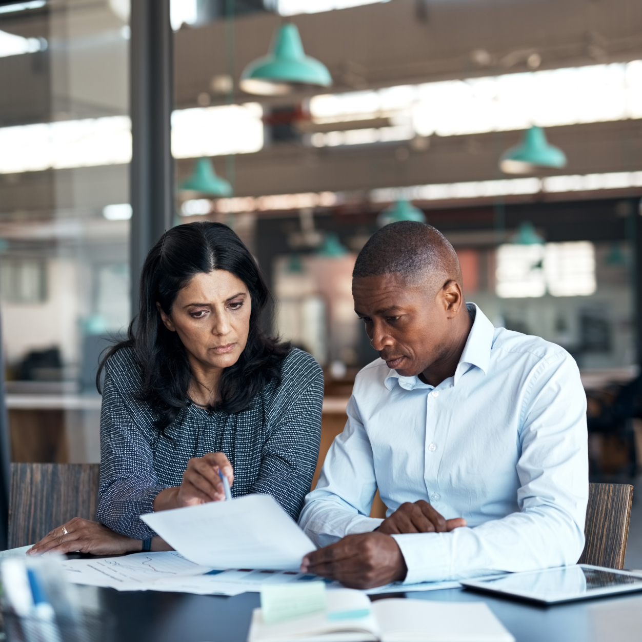 Shot of a businessman and businesswoman going over paperwork in a modern office.