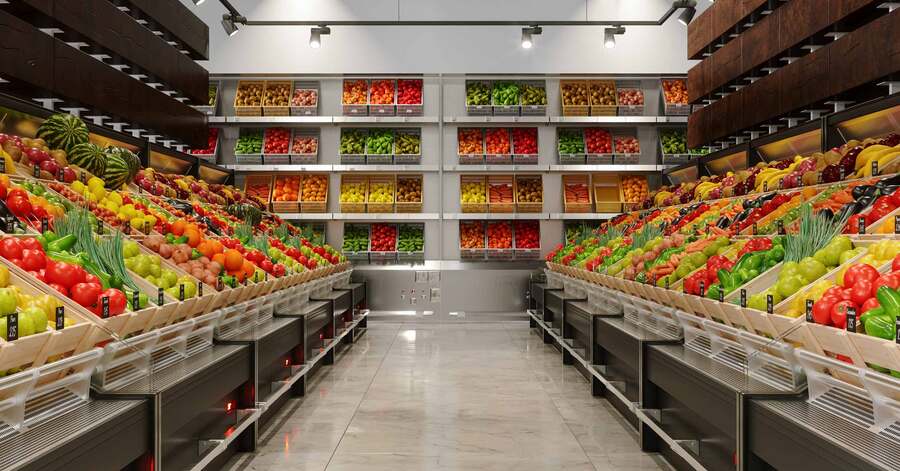 Supermarket produce section with neatly arranged fruits and vegetables.