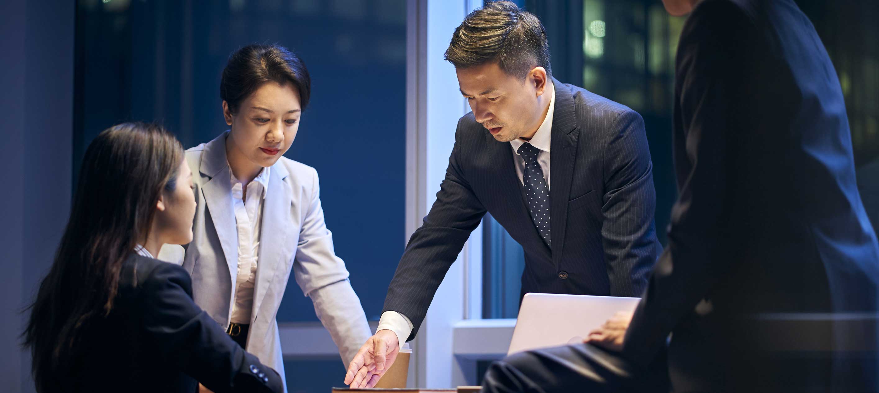 A group of business professionals discussing documents and collaborating on a strategy.