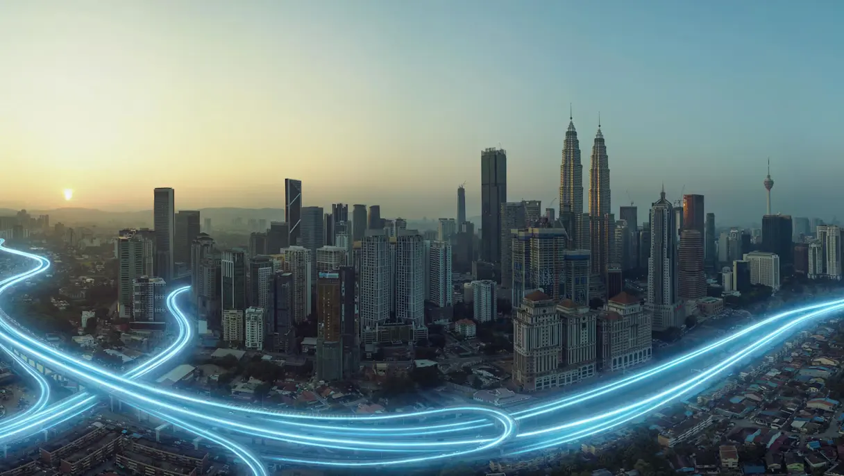 City skyline at sunset with glowing highway light trails.