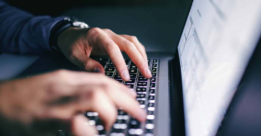Close up of hands typing on laptop.