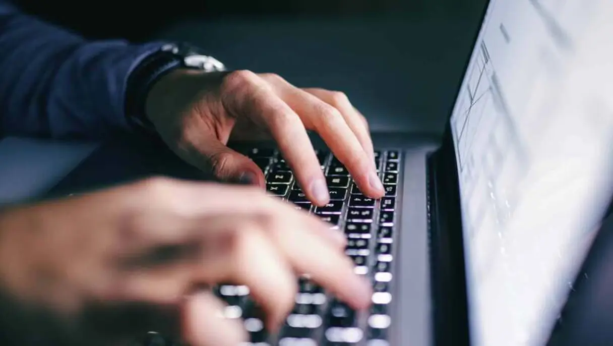Close up of hands typing on laptop.