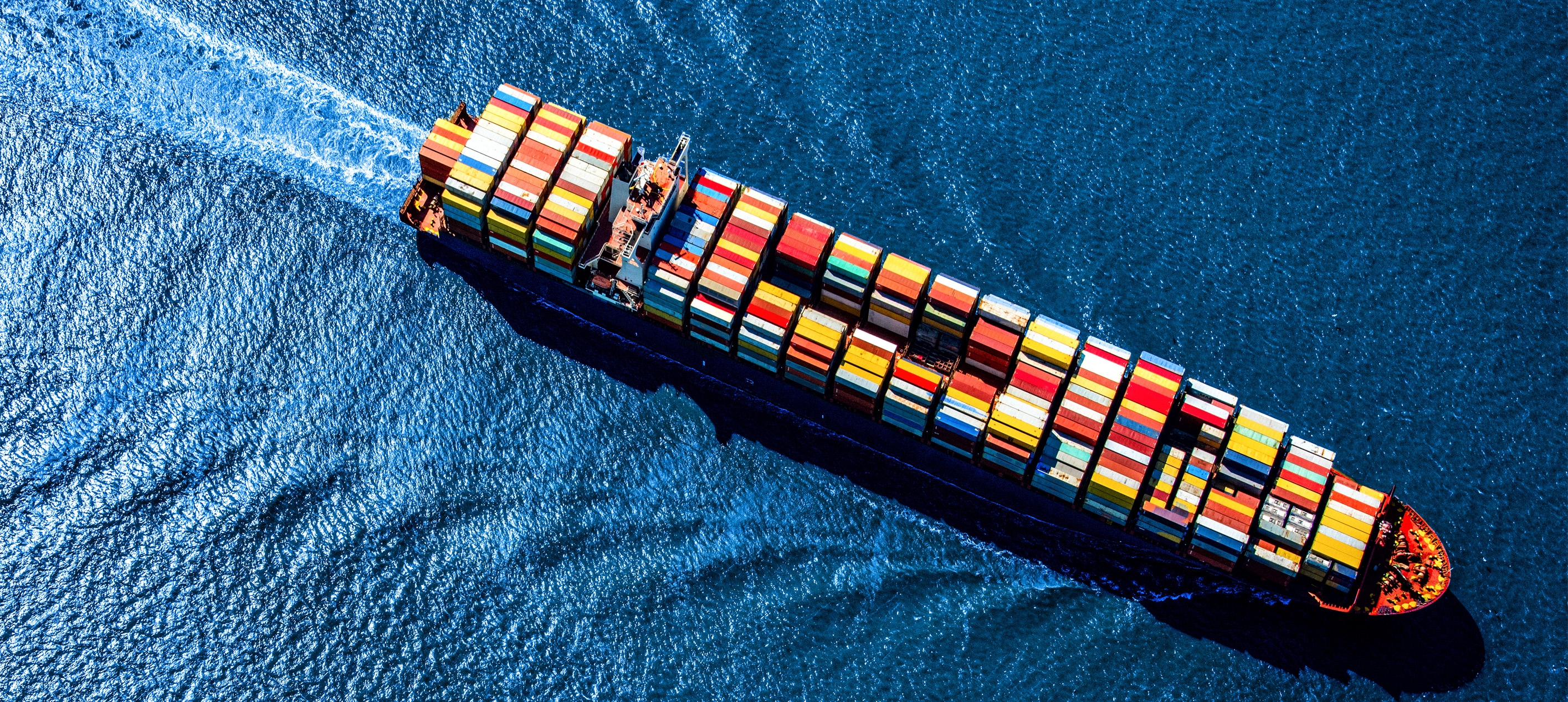Aerial view of a container ship carrying cargo at sea.