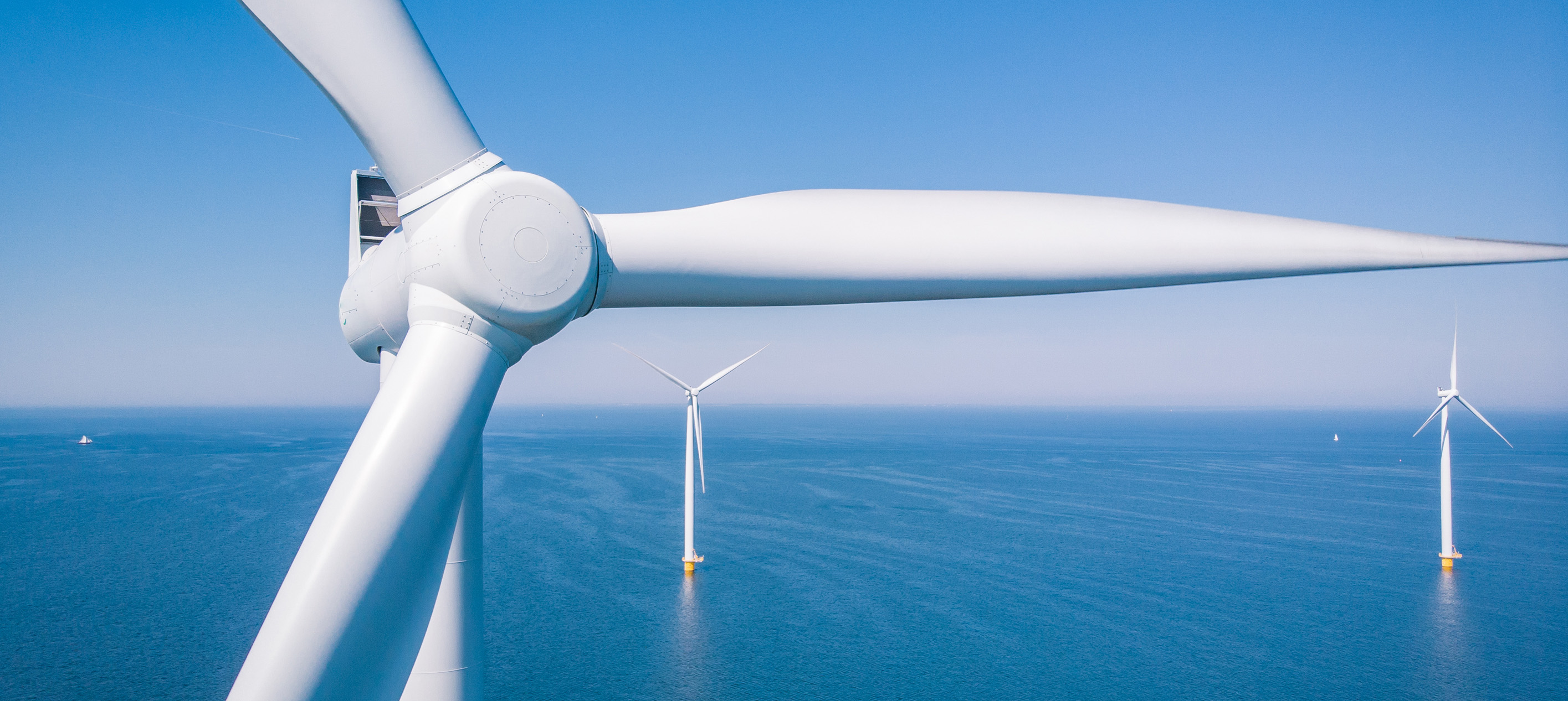 White windmills in the ocean during the daytime 