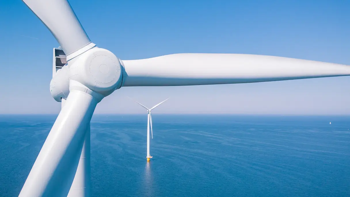 White windmills in the ocean during the daytime