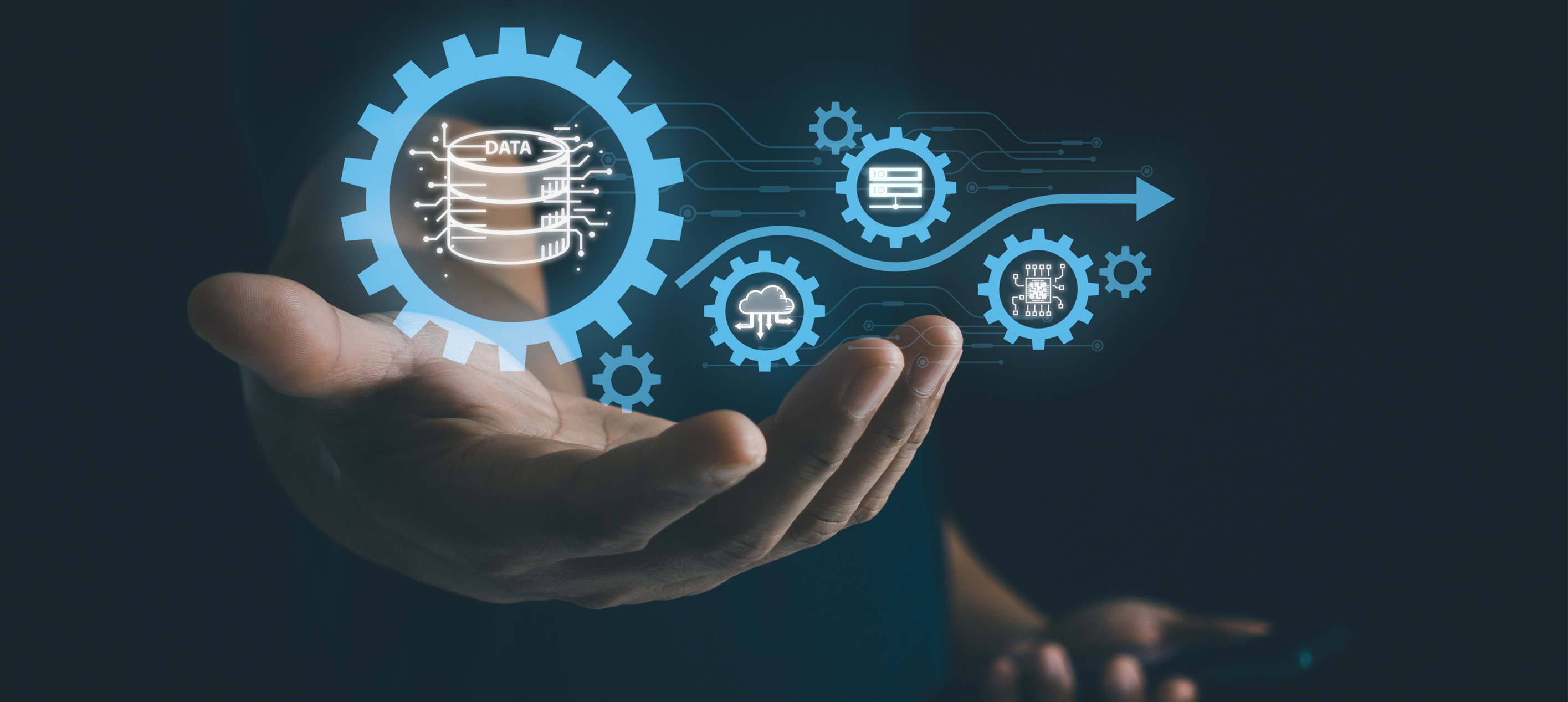 Hands held open with glowing blue gears and digital icons including a data stack, cloud and circuit board connected by a blue arrow.