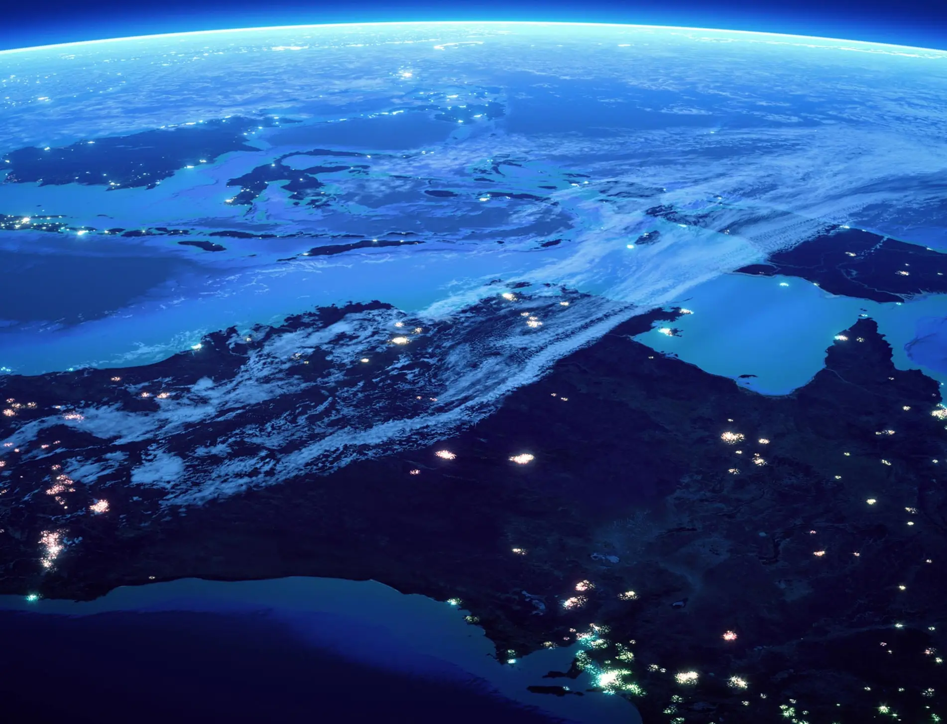 Satellite view of Australia at night, showing illuminated cities and surrounding ocean.