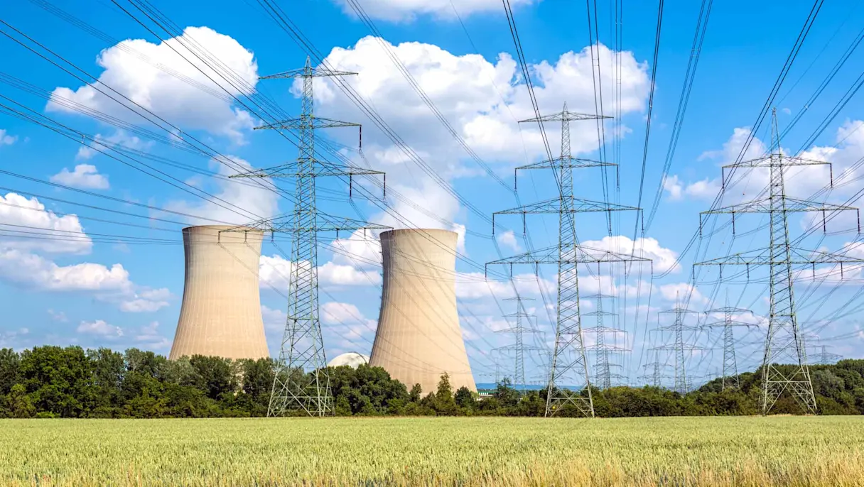 Nuclear power plant with cooling towers and power lines.