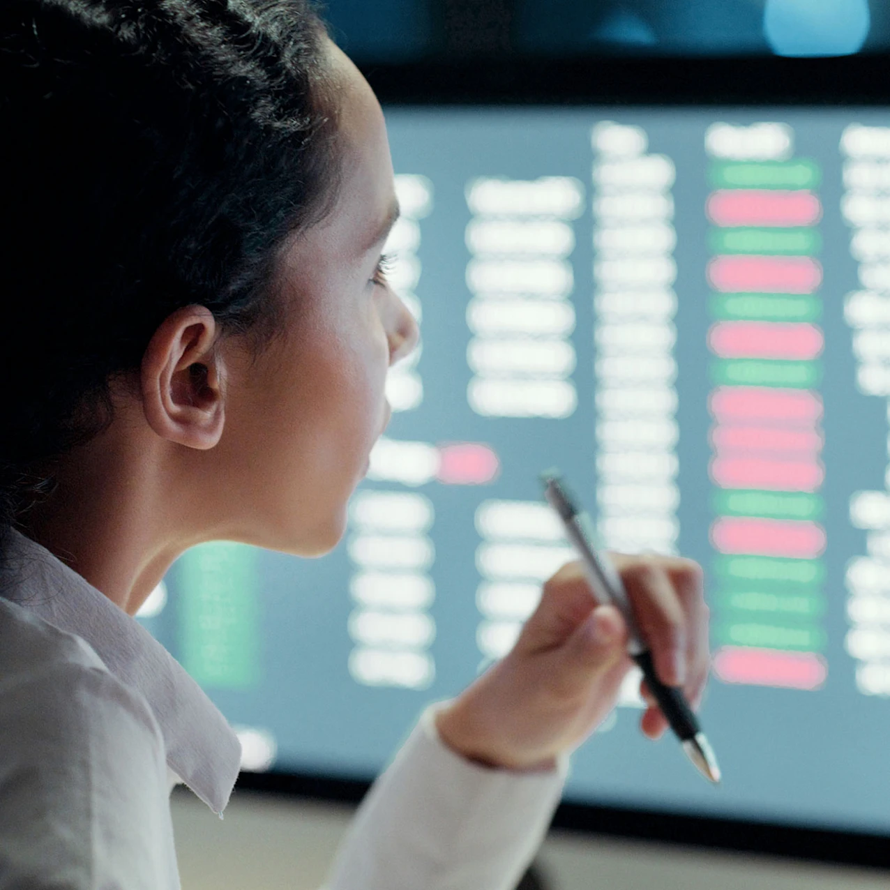 A person holding a pen looking at the screen