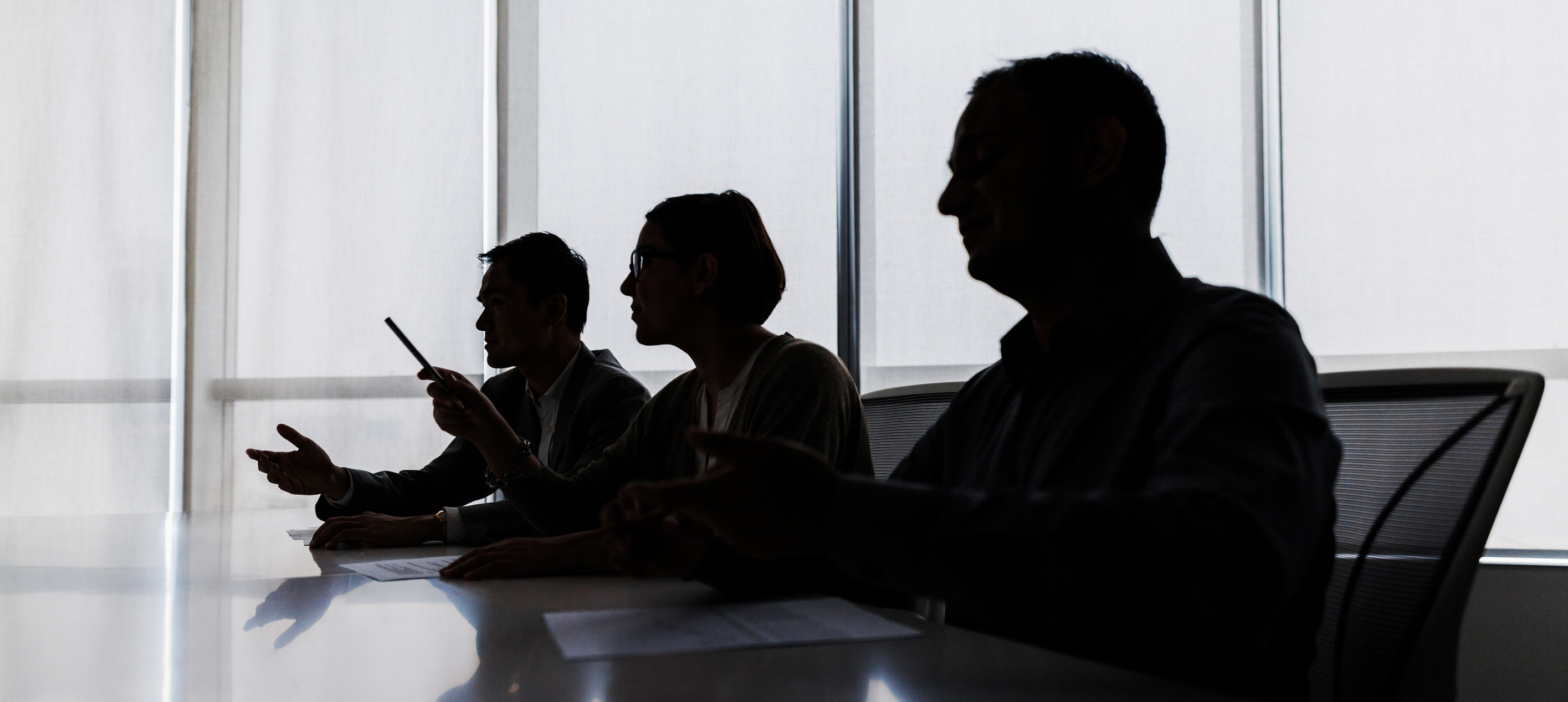 Silhouette of business people negotiating at meeting table